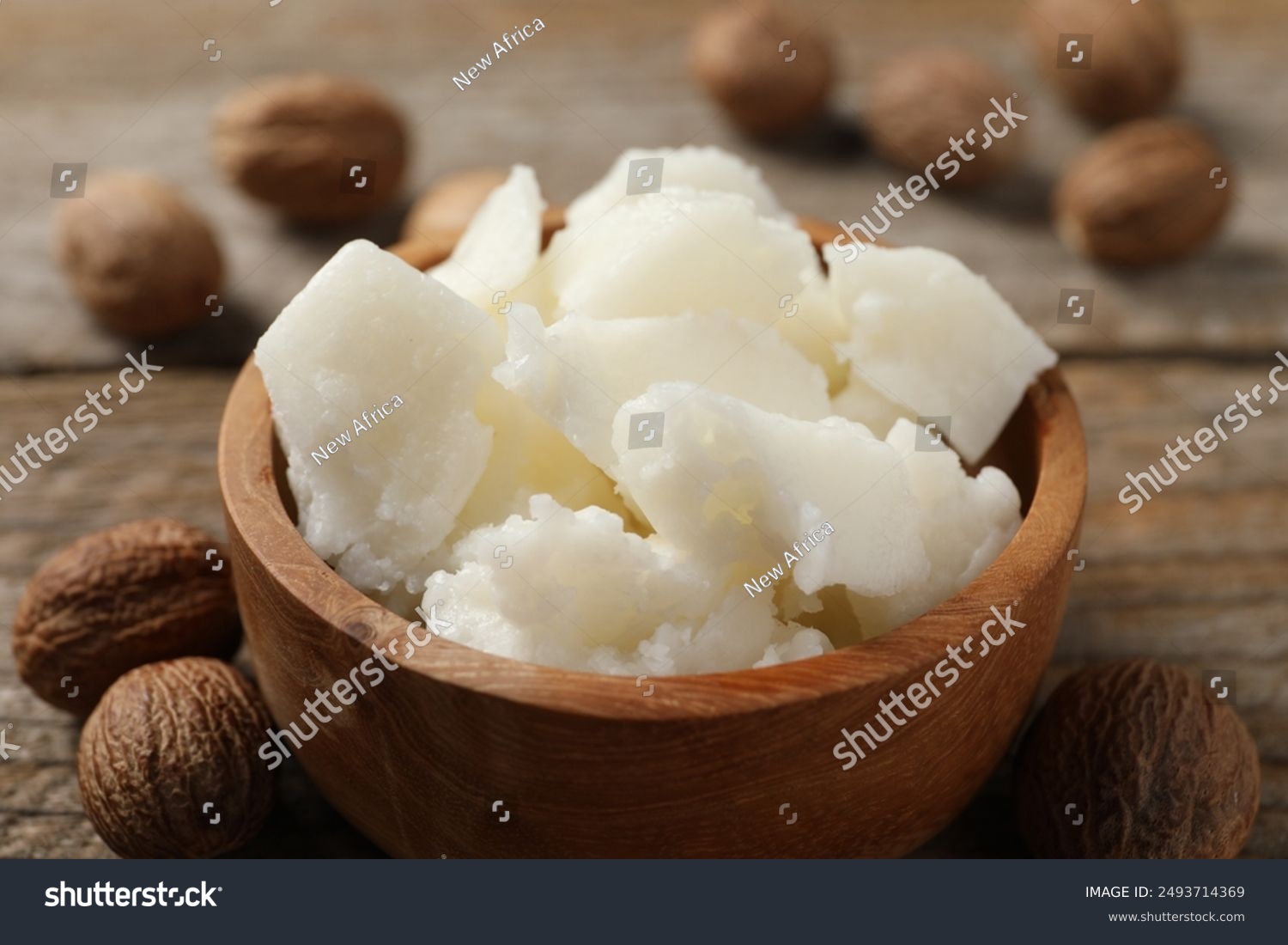 Shea butter and nuts on wooden table close-up